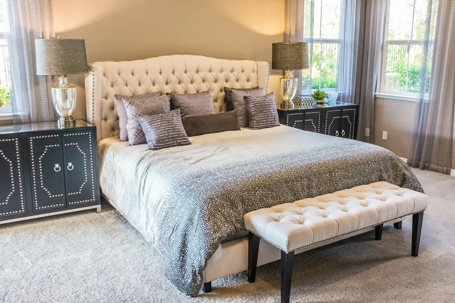 Freshly made bed with clean linens and pillows in a bright bedroom